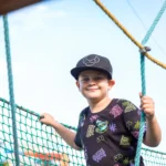 Usmiaty chlapec na nízkych lanových prekážkach Lanáčik